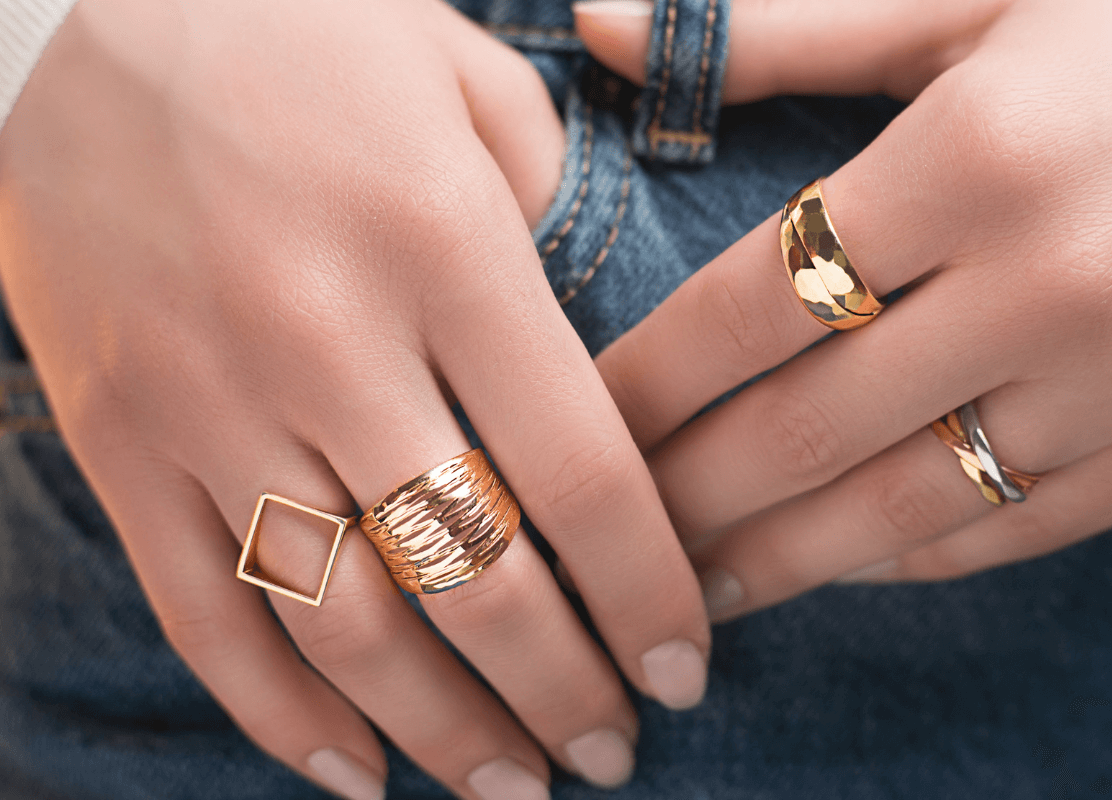 Tri prekrasna zlatna prstena na ženskim rukama simboliziraju gracioznost i individualnost.
