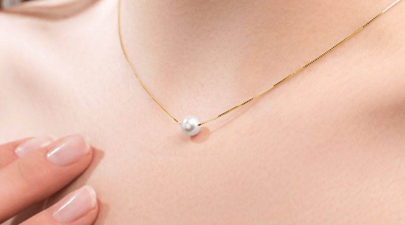 gold pearl necklace on womans neck