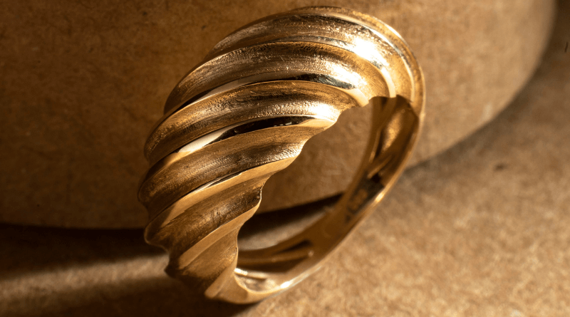 gold ring wave design on beige surface