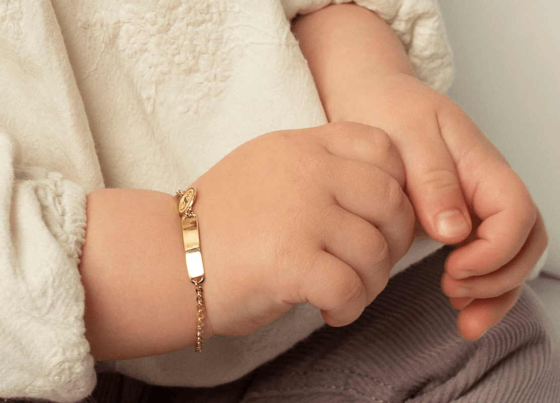  Beba sa zlatnom narukvicom na zapešću pokazuje eleganciju i šarm.