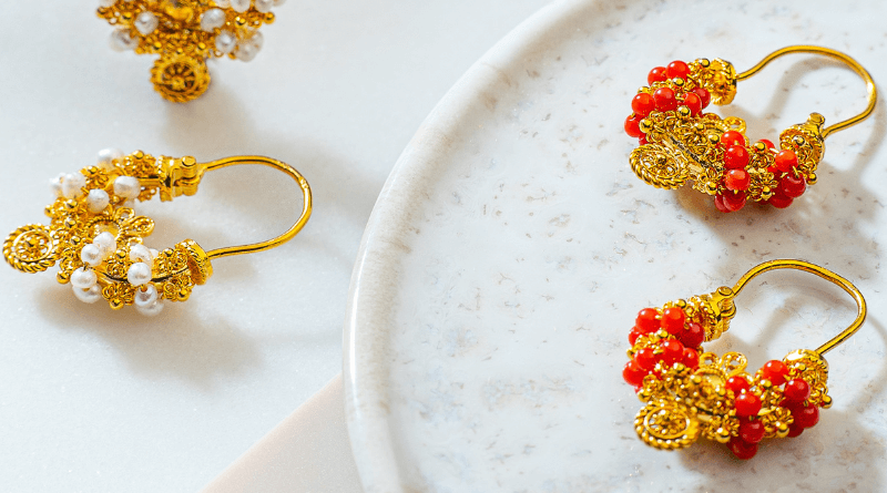gold jewelry with corals on pastel background