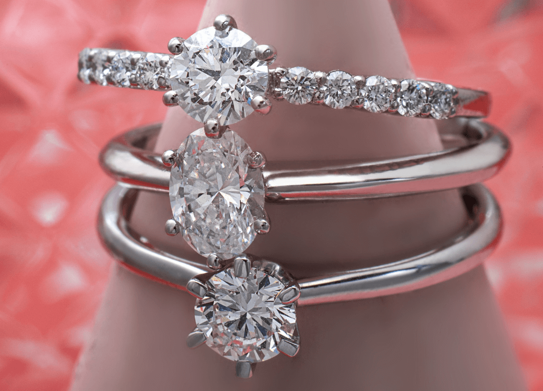 white gold engagement rings with diamonds on pink background