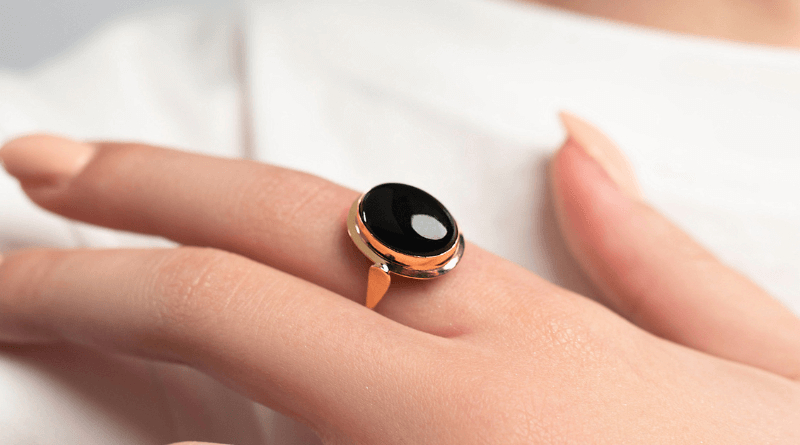 black onyx gold ring on woman finger