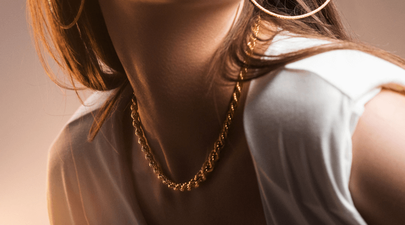 woman in white dress with 14kt gold chain around her neck