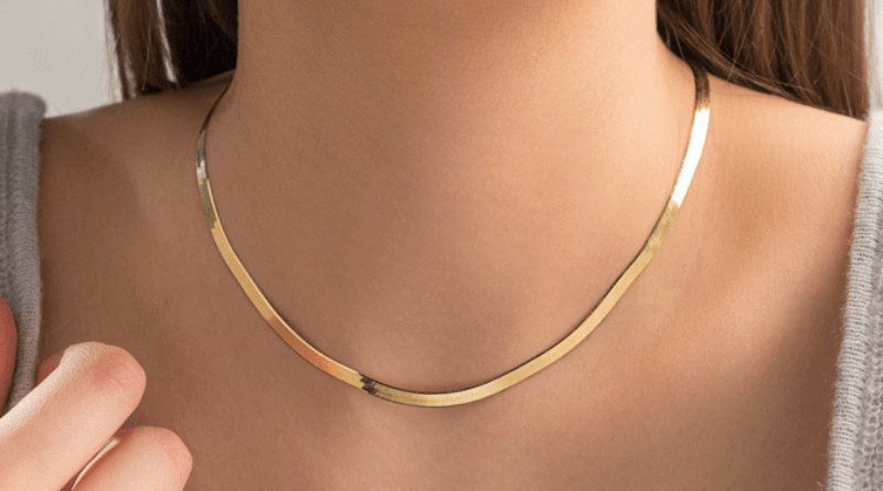 gold necklace around woman neck