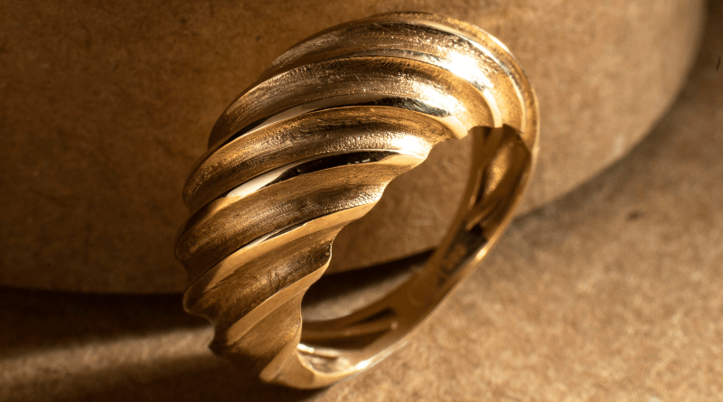 wavy premium gold ring on beige background