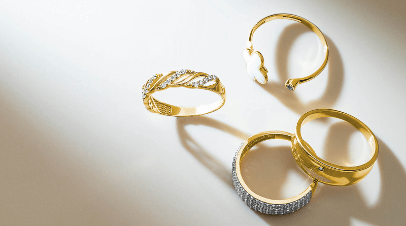gold jewelry rings on white surface