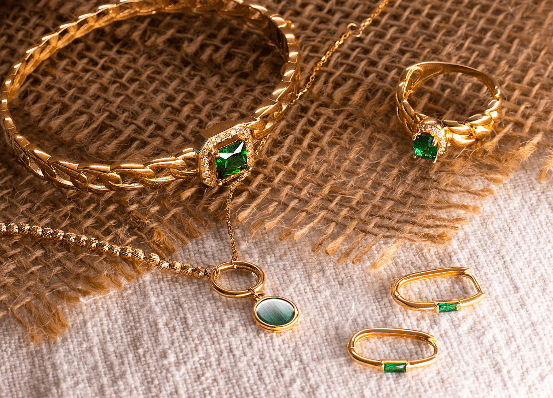  Set zlatnog nakita sa zelenim kamenjem smaragda i malahita, uključujući narukvicu, prsten i naušnice.