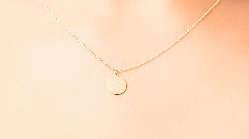 personalized gold necklace with letter engraved on it on womans neck