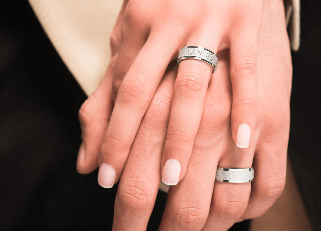 Mladenci pokazuju svoje vjenčano prstenje, označavajući vječnu ljubav i jedinstvo.