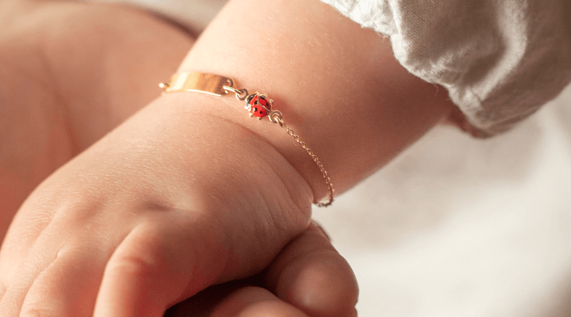 gold bracelet baby child with lady bug and name bar on baby hand