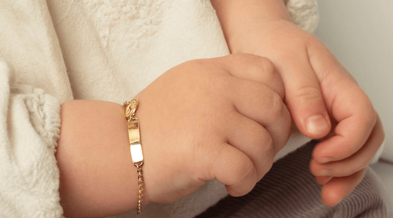 gold bracelet baby child with name bar on baby hand