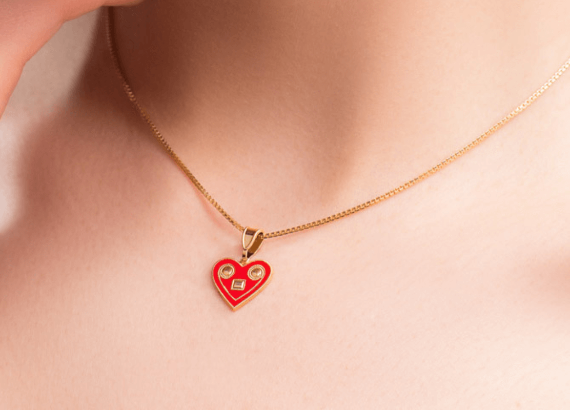 Žena nosi crveno srce licitarsko srce ogrlicu, simbol ljubavi i privrženosti.