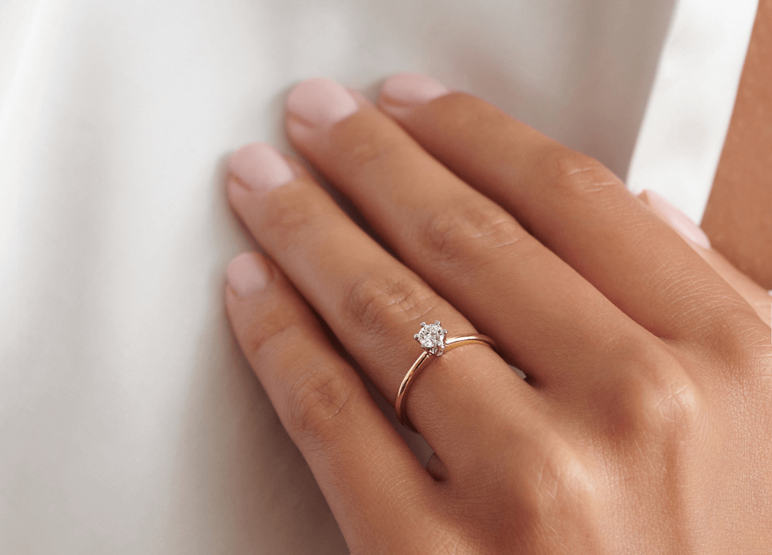 Ženska ruka sa svjetlucavim dijamantnim prstenom, zrači elegancijom i simbolizira ljubav i predanost.