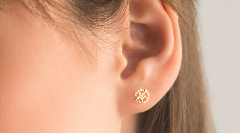 earring made of gold in shape of a star on ear