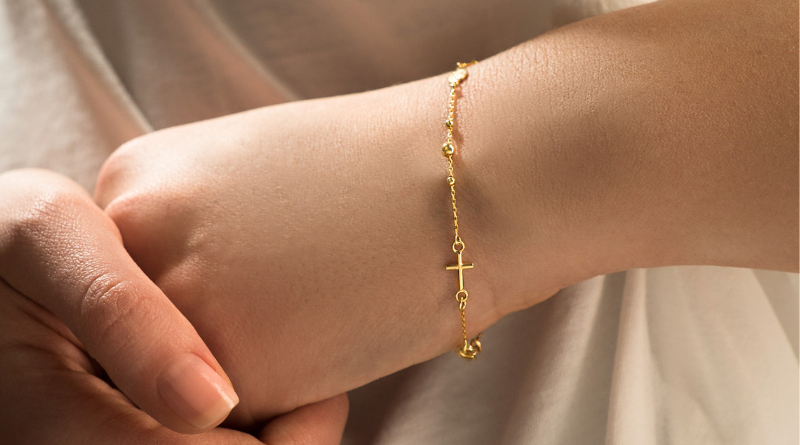 gold rosary bracelet on womans hand