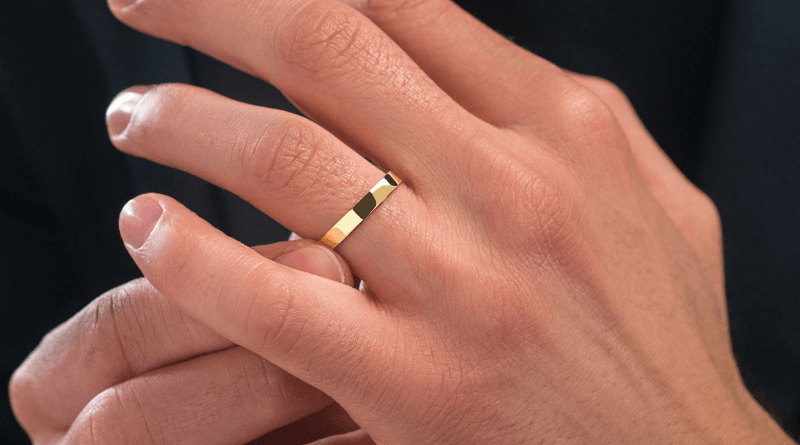 gold wedding ring band on man hand