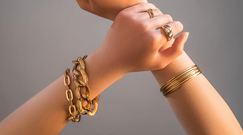 gold bracelets and rings on womans hands
