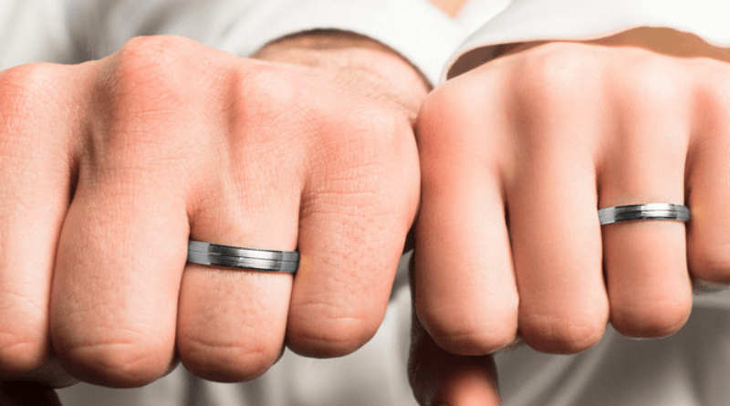 white gold wedding rings bands on hands of a couple