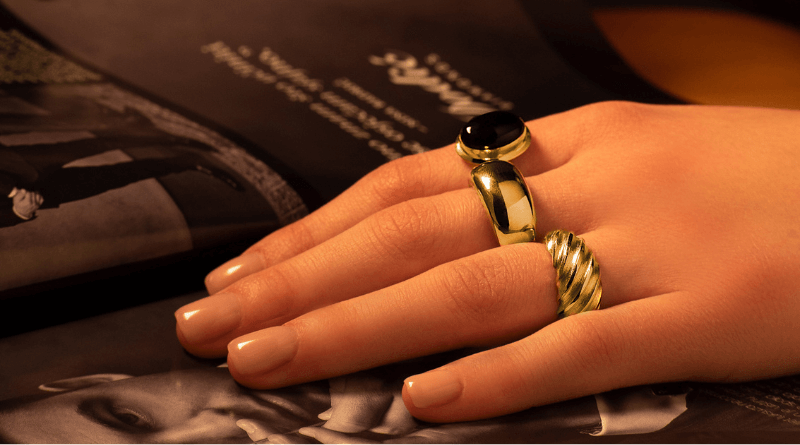 layering gold rings on woman hand
