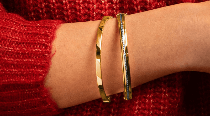 layering gold bracelets on woman hand