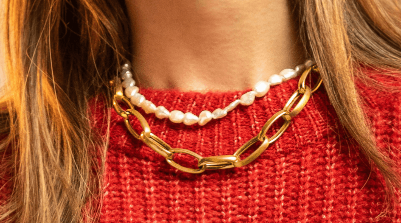layering gold necklaces on woman