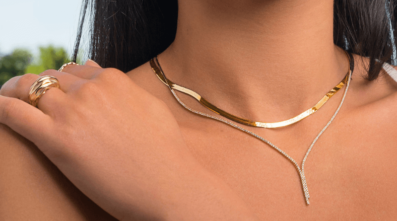 layering gold necklaces and rings on woman