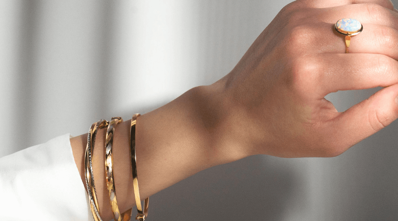 gold bracelets on hand in shadows